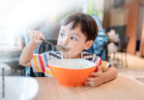 Photography Cute little boy eating delicious Roasted Duck Noodle with chopstick by himself