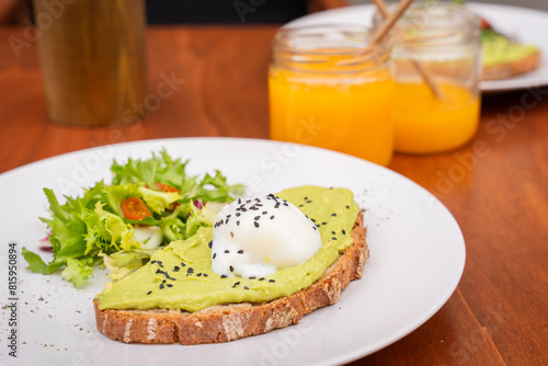 Delicious breakfast. Whole Wheat Toast with Avocado Cream topped with a Poached Egg. Toast with avocado cream and poached egg on top. selective focus. Soft focus.
