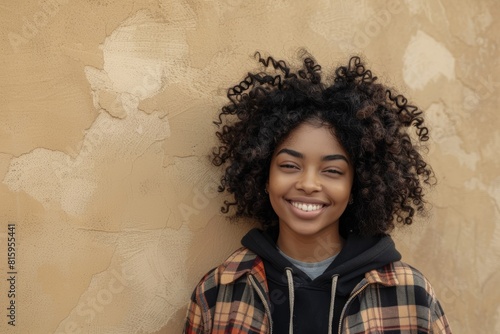 Kenyan city, metropolitan town, or fun wall background with black woman, portrait, and afro. Happy young african female smile for happiness, face and curly hair outdoors with fashion photo