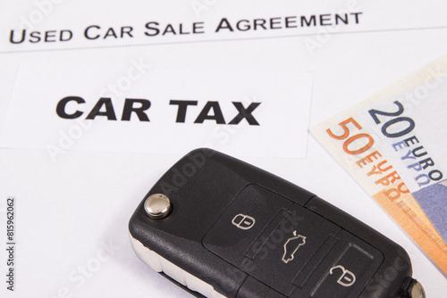 Car key, euro baknotes, inscription car tax and used car sale agreement. Sales, purchases, taxation of automobile. Transportation