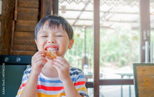 Cute asian girl eating Chicken Nugget by self. Background. Copy space.
