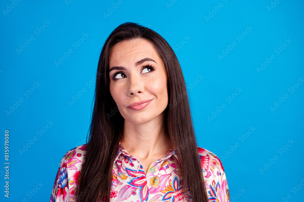 Photo of unsure thoughtful lady dressed print blouse looking empty space isolated blue color background Photo of unsure thoughtful lady dressed print blouse looking empty space isolated blue color background