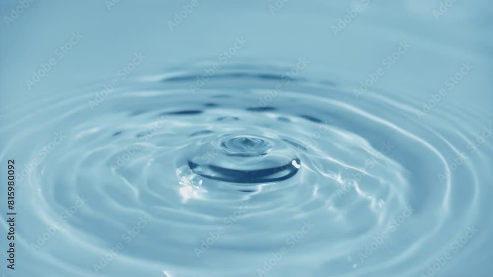 Natural mineral water splashing. Crystal clear drop of cosmetic essence serum falling in slow motion. Body moisturizing cosmetics formulating. Commercial beauty product blue liquid abstract background Natural mineral water splashing. Crystal clear drop of cosmetic essence serum falling in slow motion. Body moisturizing cosmetics formulating. Commercial beauty product blue liquid abstract background
