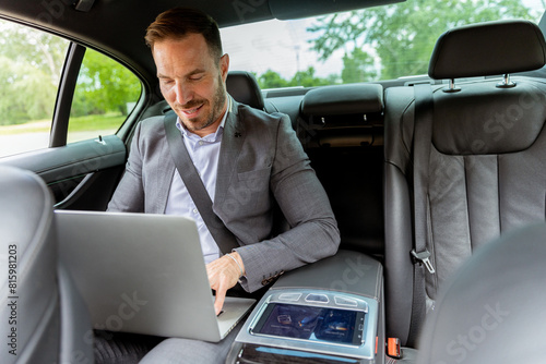 Business executive working on laptop in car during morning commute © BGStock72
