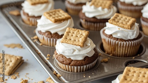 Baking s mores cupcakes by placing graham crackers in cupcake liners photo