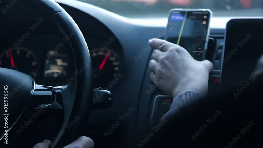 Person drives a car with a cell phone with a navigator on the dashboard. Person drives a car with a cell phone with a navigator on the dashboard.