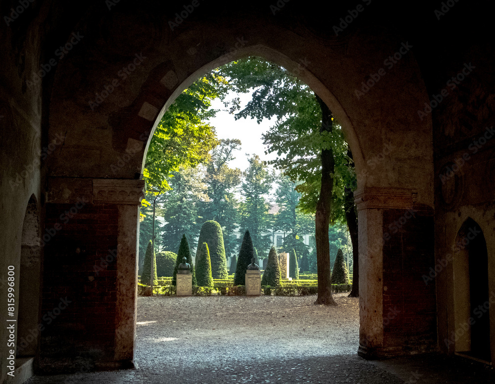 Fototapeta premium Vue sur le parc de la Piazza Pallone depuis une arche du palais ducal de Mantoue en Italie