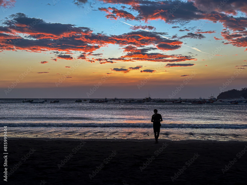 Naklejka premium Silhouette of a Couple in love watching the sunset at the magnificent San Juan Del Sur Beach in Nicaragua