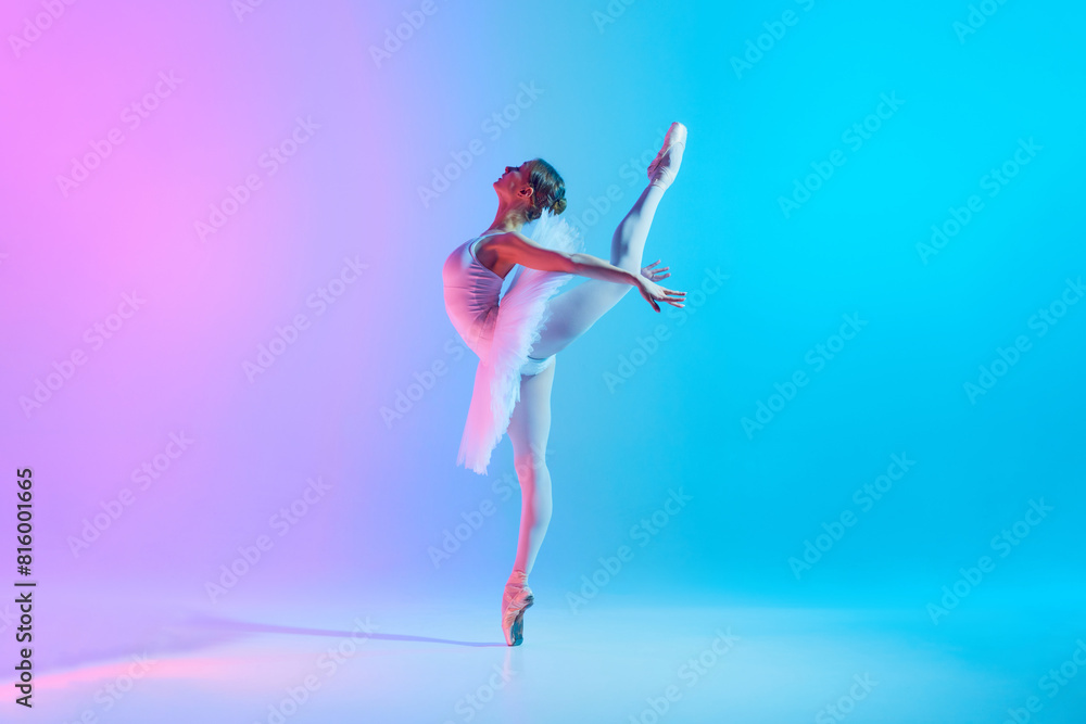 Tenderness and grace. Portrait of young flexible ballerina dancing in neon light against vivid gradient background. Concept of art, movement, classical and modern fusion, beauty and fashion. Ad