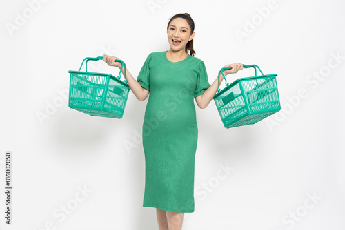 Asian pregnant woman smile and holding green grocery basket isolated on white background, Shopping and Supermarket concept