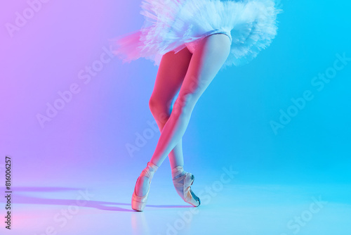 Cropped photo of young, slim ballet dancer in white tutu and pointe in neon light against vivid gradient background. Concept of art, movement, classical and modern fusion, beauty and fashion. Ad
