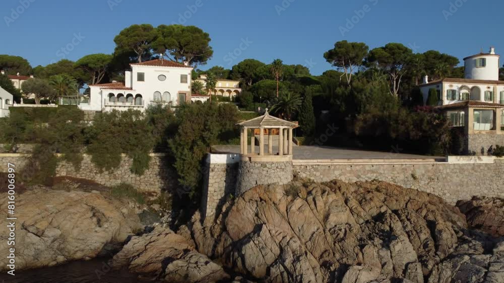 Pergola gazebo in front of the sea with a drone view of the Mediterranean Sea. Viewpoint located in camí de Ronda (Coastline of Costa Brava, Catalonia, Spain, S'Agaro) Pergola gazebo in front of the sea with a drone view of the Mediterranean Sea. Viewpoint located in camí de Ronda (Coastline of Costa Brava, Catalonia, Spain, S'Agaro)