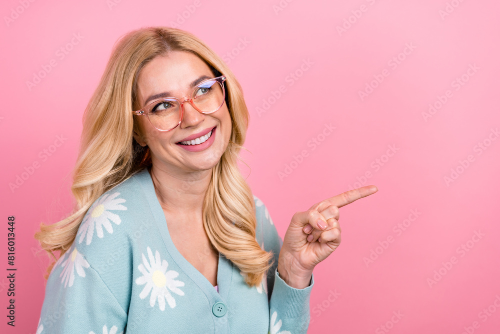 Photo of nice woman with wavy hair dressed print cardigan in glasses directing look at promo empty space isolated on pink color background Photo of nice woman with wavy hair dressed print cardigan in glasses directing look at promo empty space isolated on pink color background