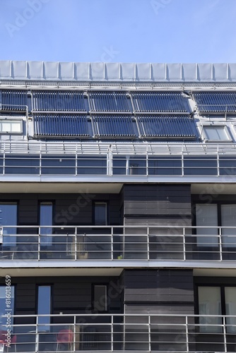 Solar panels on the roof of a multi-story modern building.
