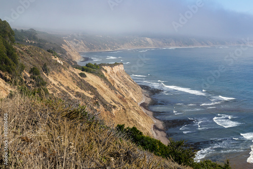 a foggy morning on the coast of Point Reyes national sea shore area. With a beautiful view over the sandstone mountains that forms the iconic coastline photo