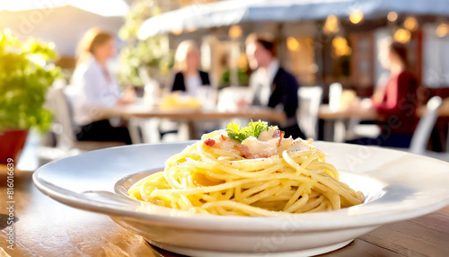 Spaghetti Cabonara, im Hintergrund ein Restaurant mit Gästen