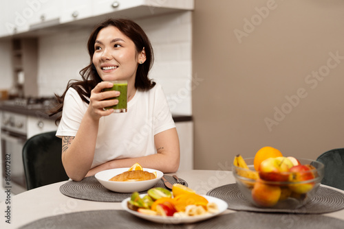 Young Woman Enjoying Healthy Breakfast In Modern Kitchen. Casual Lifestyle With Positive, Fresh Start And Healthy Eating. Smiling, Relaxed, Wellness, Morning Routine.