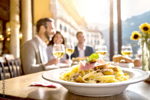 Pasta mit Maronen und Parmaschinken, im Hintergrund glückliche Gäste 