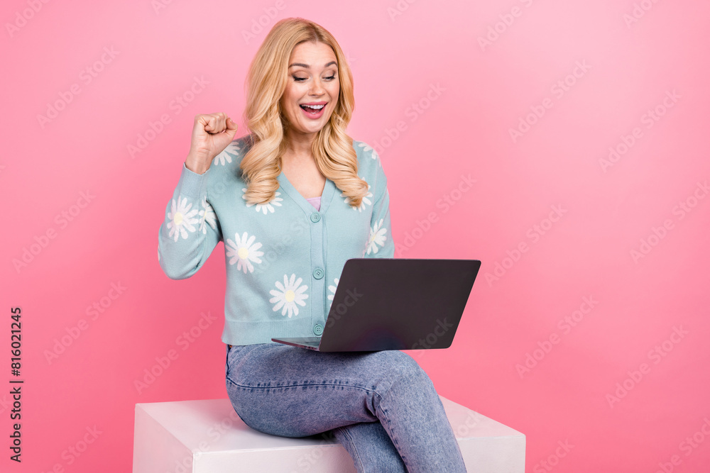 Photo portrait of lovely young woman sit white cube netbook winning dressed stylish flower print garment isolated on pink color background Photo portrait of lovely young woman sit white cube netbook winning dressed stylish flower print garment isolated on pink color background