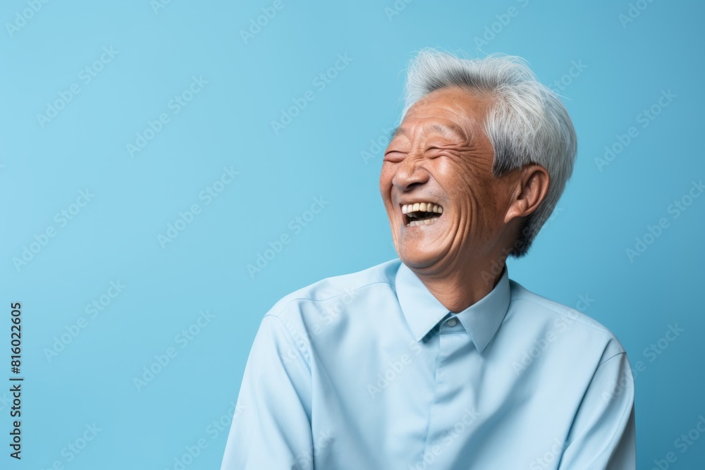 Portrait of a cheerful asian elderly man in his 90s laughing isolated in soft blue background Portrait of a cheerful asian elderly man in his 90s laughing isolated in soft blue background
