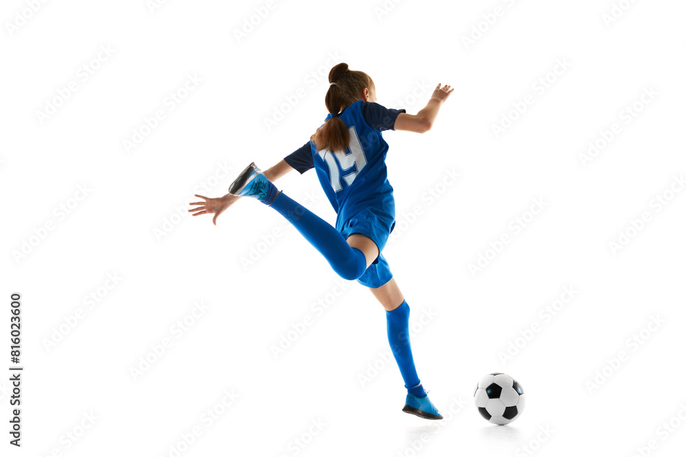 Athletic teen girl, football player in blue uniform practicing, playing isolated on white studio background. Concept of sport, active and healthy lifestyle, childhood, school, hobby Athletic teen girl, football player in blue uniform practicing, playing isolated on white studio background. Concept of sport, active and healthy lifestyle, childhood, school, hobby