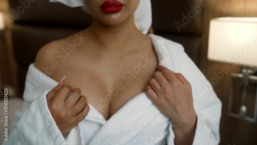 Sexy woman in lace lingerie erotically takes off her robe. Sexy young woman takes off her robe in a hotel room.
