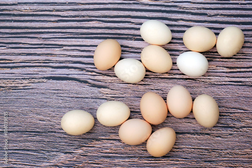 Groups of organic chicken eggs scattered on the wood-patterned floor are eggs that come from chickens raised on organic food. There are no toxic residues that are harmful to the body.