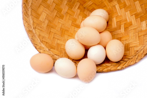 Organic chicken eggs in a bamboo basket on a white background are eggs that come from chickens raised on organic food. They do not contain toxic residues that are harmful to the body.  