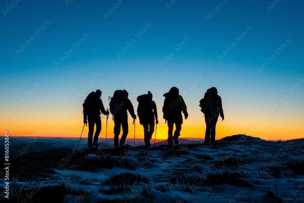 silhouette of five hikers walking on top of a mountain at dusk, with blue sky and orange glow in the background  as they walk towards horizon conveying their unity during an epic journey Generative AI