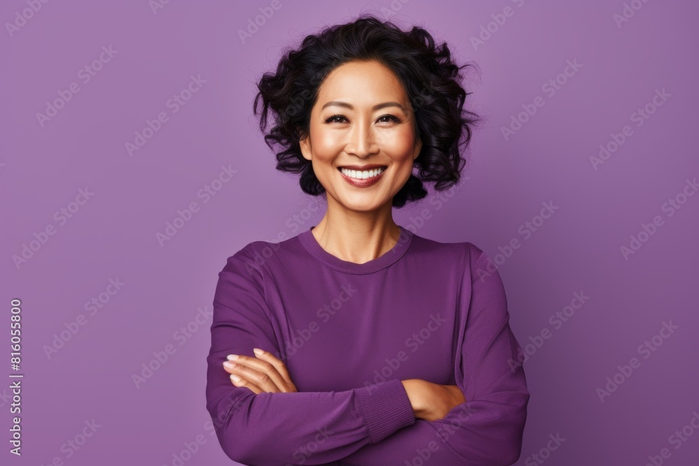 Portrait of a happy asian woman in her 40s with arms crossed in soft purple background Portrait of a happy asian woman in her 40s with arms crossed in soft purple background
