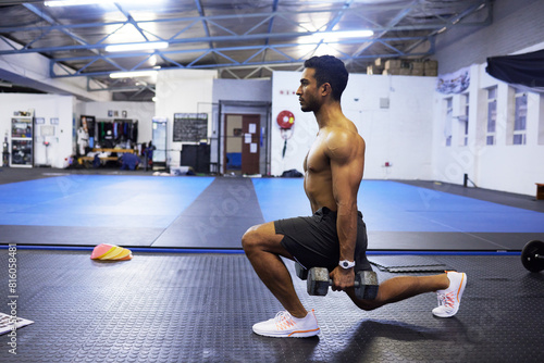Man, dumbbells and lunge in exercise at gym, weightlifting and training for power or strong legs. Male person, shirtless and fitness for muscle development, athlete and bodybuilder for challenge