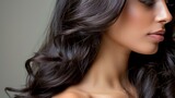  A tight shot of a woman's face with long, dark tresses and a diamond stud in her left ear