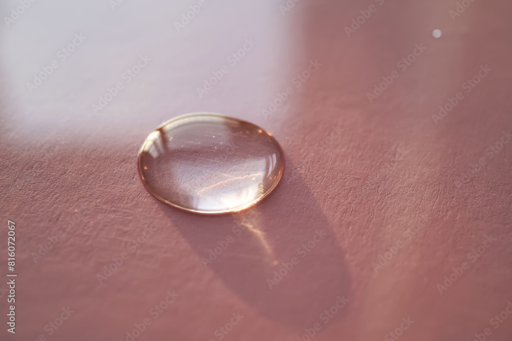Beautiful volumetric drop of cosmetic product on a pink background. Beautiful volumetric drop of cosmetic product on a pink background.