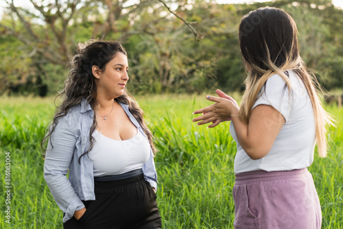 two Latin friends talking and arguing, while taking a walk in the park they gossip about their lives