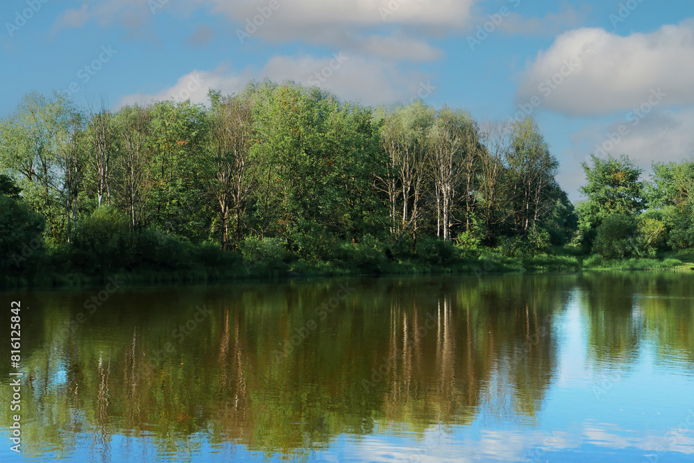 Lake with reflection of forest and sky water.