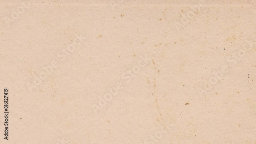 Vintage paper texture 4K stop motion video. Aged old page overlay effect background loop animation. Kraft paper texture with stains, grain, dust particles. Empty abstract animated backdrop