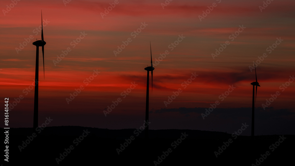 Wind Turbines Silhouette at Sunset with Red and Orange Sky, Renewable Energy Landscape