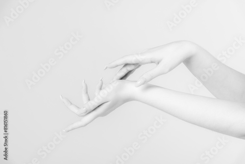 Close-up side view of elegant female hands touching each other during dance against grey background. Soft focus. White on white. Self expression theme.