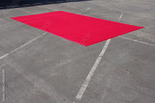 Red carpet on the asphalt of an event space parking lot