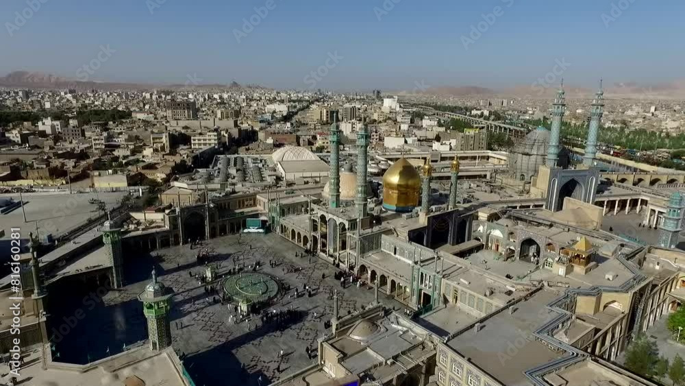 Aerial journey above the majestic Fatima Masumeh Shrine alongside bustling urban landscape surrounding the shrine. Aerial journey above the majestic Fatima Masumeh Shrine alongside bustling urban landscape surrounding the shrine.