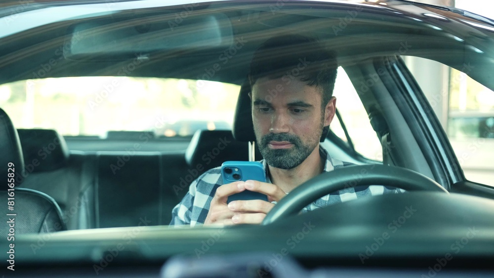 Smiling male driver using mobile phone while sitting in the car. Transport, technology, lifestyle concept.
