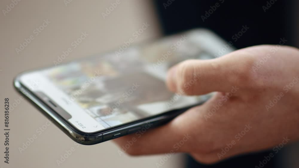 Close up of guy scrolling social media news feed on smartphone Close up of guy scrolling social media news feed on smartphone