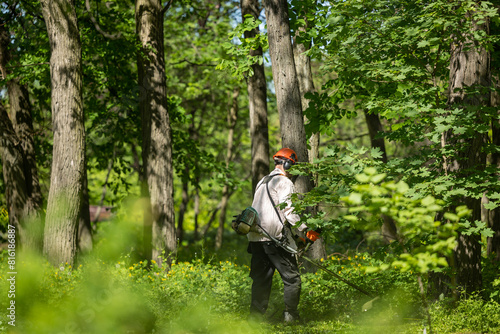 A man is mowing the grass with a manual lawnmower