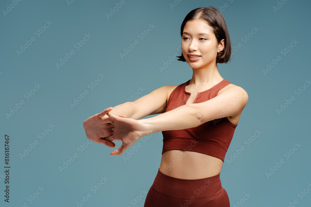 Portrait of positive attractive asian woman stretching standing isolated Portrait of positive attractive asian woman stretching standing isolated