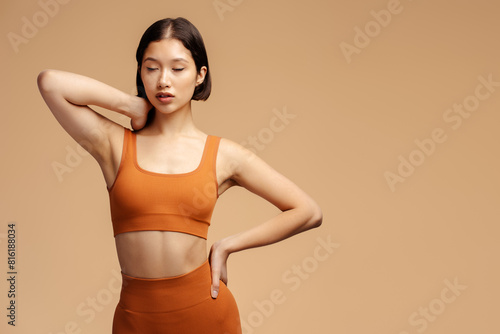 Serious sportswoman wearing fitness uniform, looking away isolated