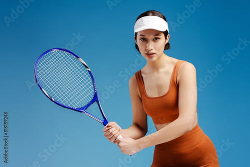 Serious girl tennis player in sportswear holding tennis racket on isolated © Maria Vitkovska