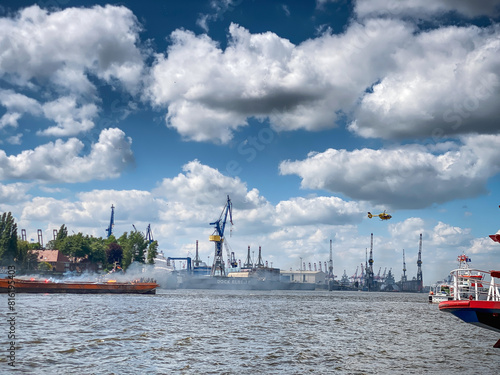 Rettungsaktion auf der Elbe: Seenotkreuzer und Hubschrauber im Einsatz vor dem Hintergrund des Hamburger Hafens photo