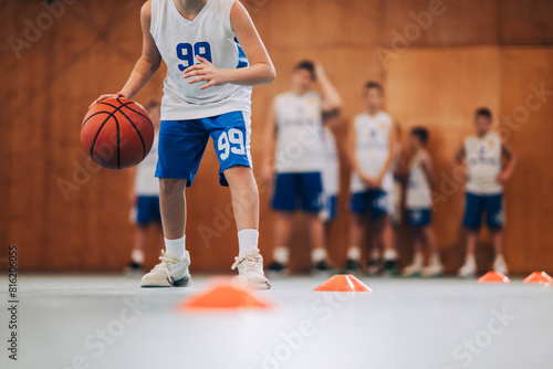 Bilde på lerret Cropped image of junior basketball player dribbling ball on training
