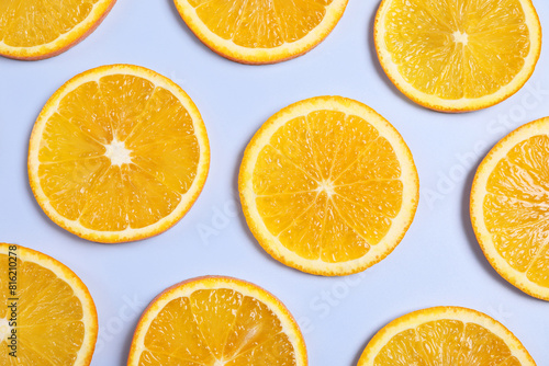 Slices of juicy orange on light blue background  flat lay