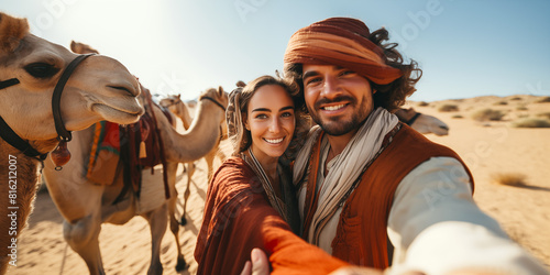 Pareja de turistas felices tomándose fotos selfie para su blog de viajes en el desierto del Sahara en Marruecos. Viajes y aventuras por el mundo.